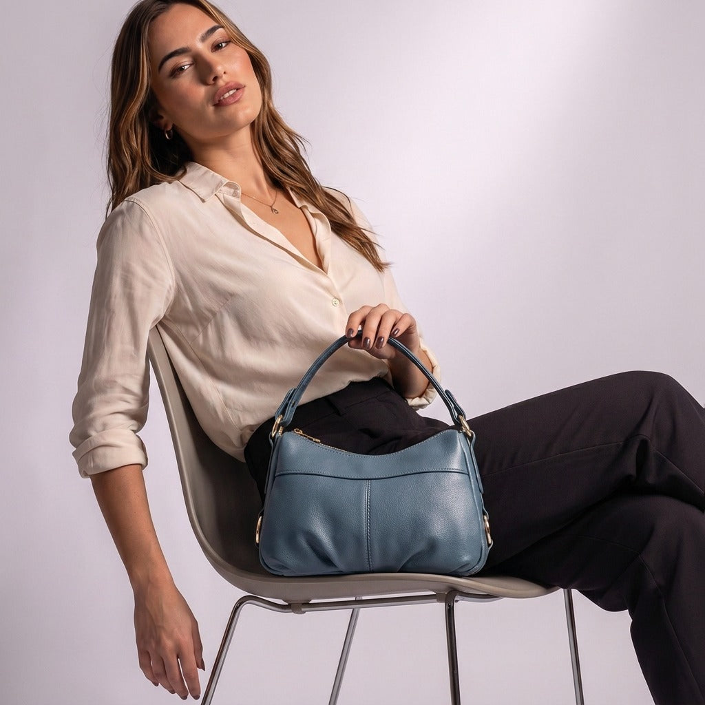 Femme assise avec le sac à main souple Joséphine bleu sur les genoux