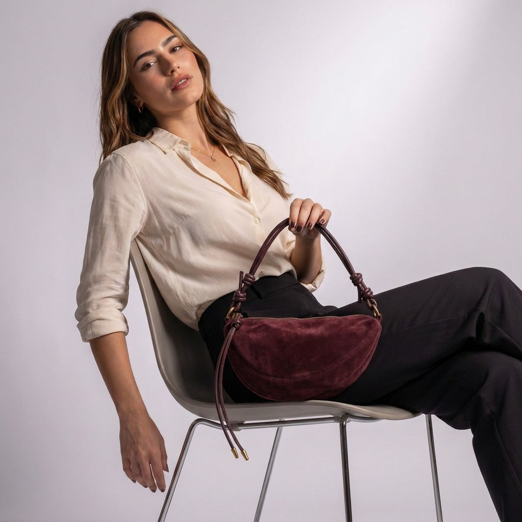 Femme assise avec le sac croissant Héloïse bordeaux sur les genoux