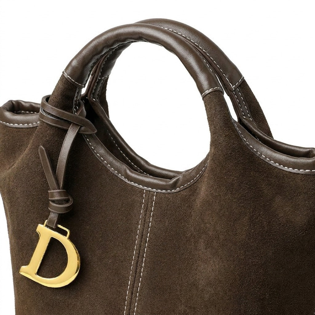 Détail de l'anse ronde surpiquée et du bijou doré en D du sac Viviane chocolat