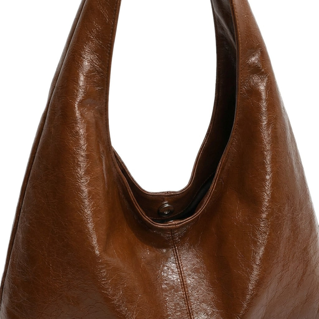 Détail du cuir glacé froissé et du bouton-pression du sac hobo Jeanne cognac