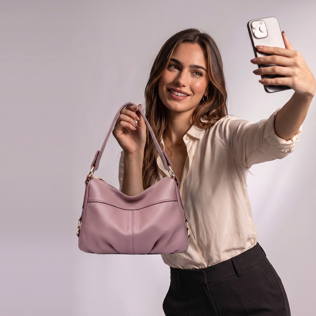 Femme souriante levant le sac à main Joséphine vieux rose tenu par l'anse