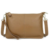 Pochette en cuir grainé camel Suzanne avec dragonne et bandoulière, vue de face sur fond blanc