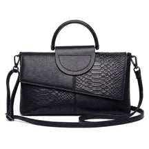 Sac à main en cuir noir Ombeline effet croco, rabat asymétrique et anse ronde, vue de face sur fond blanc