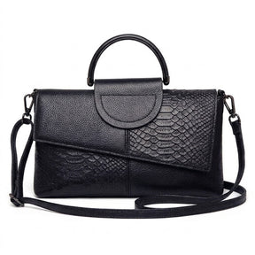 Sac à main en cuir noir Ombeline effet croco, rabat asymétrique et anse ronde, vue de face sur fond blanc