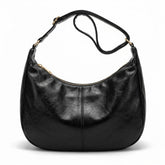 Sac hobo en cuir noir Colombe avec large sangle à boucle dorée, vue de face sur fond blanc
