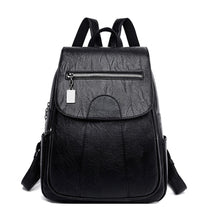 Sac à dos en cuir noir Marceline à rabat avec poche zippée, vue de face sur fond blanc
