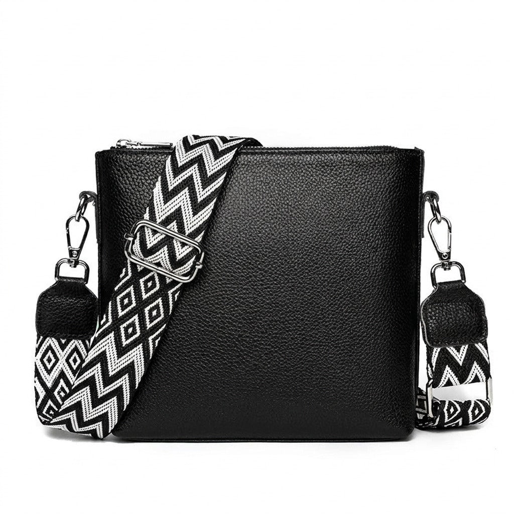 Petit sac bandoulière en cuir noir Romane avec sangle tissée, vue de face sur fond blanc