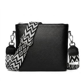 Petit sac bandoulière en cuir noir Romane avec sangle tissée, vue de face sur fond blanc
