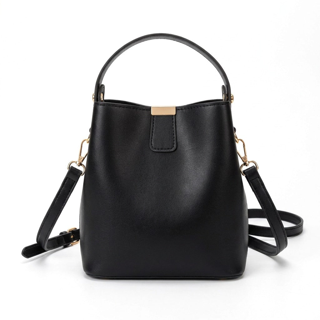 Petit sac seau en cuir noir Sidonie avec patte à plaque dorée, vue de face sur fond blanc