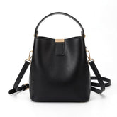 Petit sac seau en cuir noir Sidonie avec patte à plaque dorée, vue de face sur fond blanc