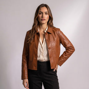 Femme portant la veste Léontine cognac ouverte sur un chemisier ivoire