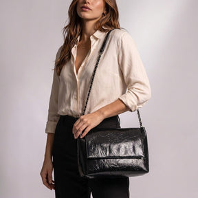 Femme portant le sac cabas Valentine noir à l'épaule par sa chaîne