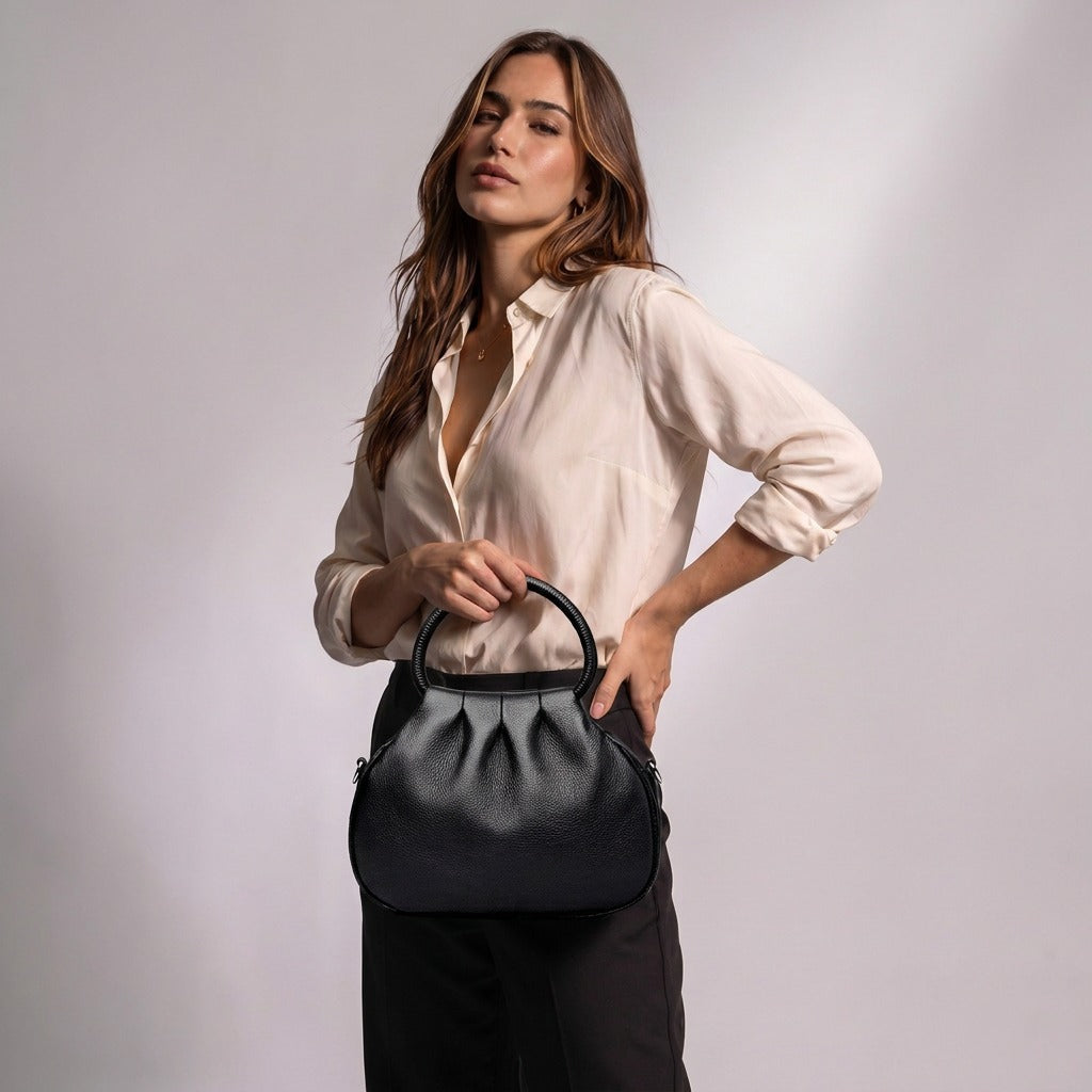 Femme tenant le sac à main Apolline noir par son anse ronde