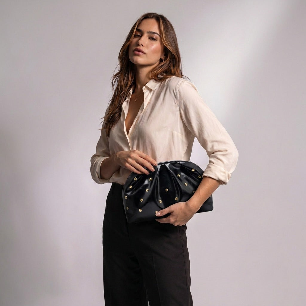 Femme tenant la pochette plissée Honorine noire à la main