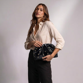 Femme tenant la pochette plissée Honorine noire à la main