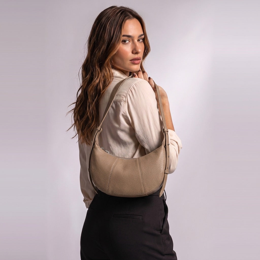 Sac demi-lune Eugénie taupe porté à l'épaule, calé sous le bras, vu de dos