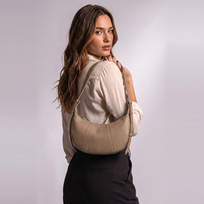Sac demi-lune Eugénie taupe porté à l'épaule, calé sous le bras, vu de dos