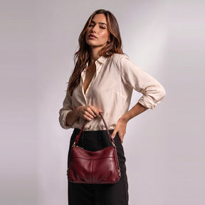Femme tenant le sac à main souple Joséphine rouge par son anse plate