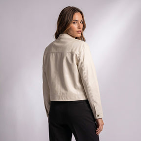 Femme de dos dans la veste en cuir Pauline, regard par-dessus l'épaule