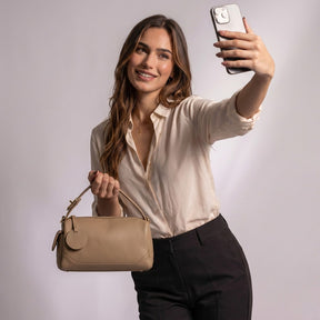 Femme prenant un selfie avec le sac bowling Lucille beige à la main