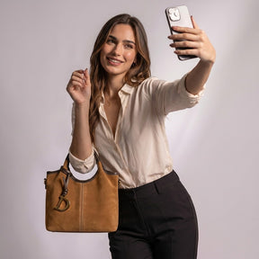 Femme prenant un selfie avec le sac cabas Viviane camel au creux du bras