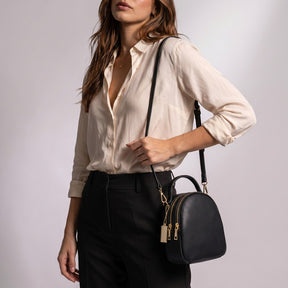 Mini sac à dos Philippine noir porté à l'épaule par sa sangle fine