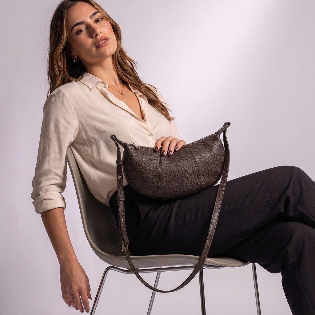 Femme assise avec le sac demi-lune Eugénie chocolat posé sur les genoux