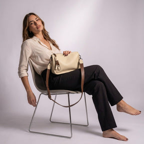 Femme assise avec le sac besace Clarisse beige sur les genoux