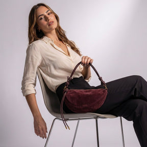 Femme assise avec le sac croissant Héloïse bordeaux sur les genoux