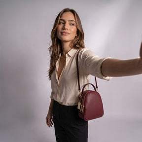 Femme portant le mini sac à dos Philippine bordeaux sur l'épaule