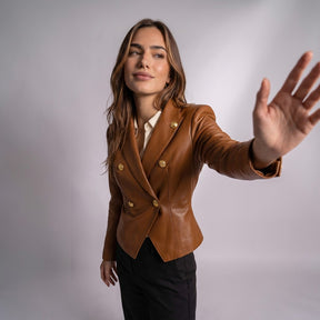 Femme tendant le bras, vêtue de la veste croisée Bertille cognac