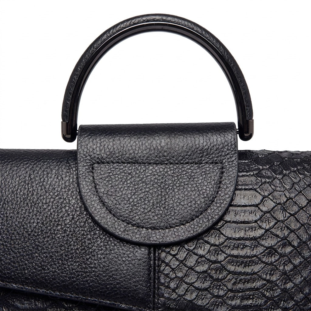 Détail de l'anse ronde, de la patte demi-lune et du cuir effet croco du sac Ombeline noir