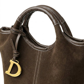 Détail de l'anse ronde surpiquée et du bijou doré en D du sac Viviane chocolat