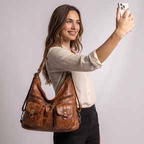 Femme prenant un selfie avec le sac Nine cognac à l'épaule