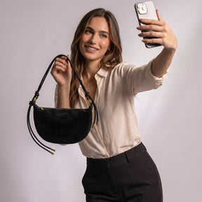Femme prenant un selfie avec le sac croissant Héloïse noir à la main