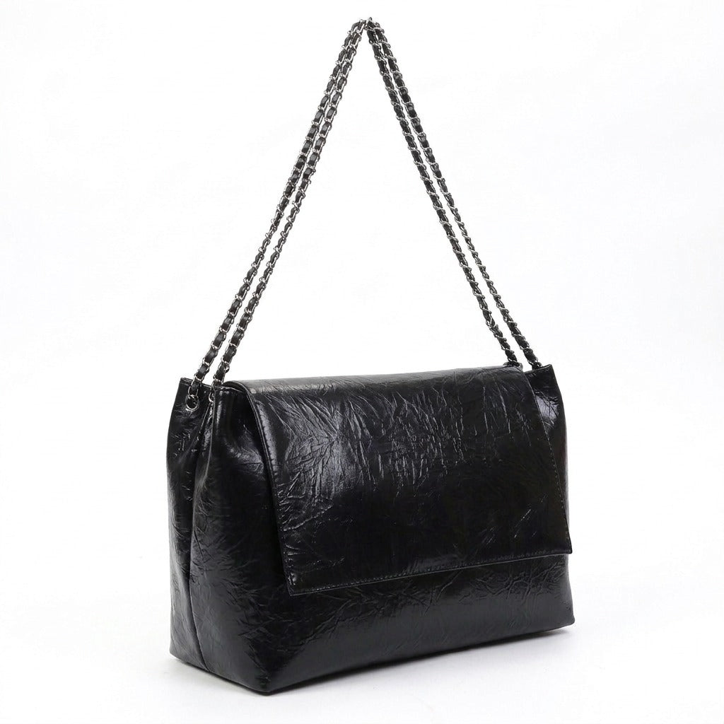 Sac cabas Valentine noir vu de trois quarts, soufflet et chaîne argentée