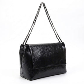 Sac cabas Valentine noir vu de trois quarts, soufflet et chaîne argentée