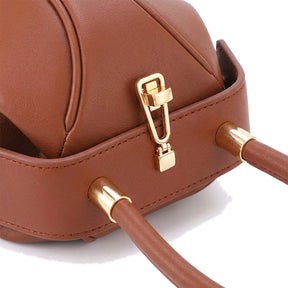 Détail du fermoir doré et des embouts de l'anse du sac boule Faustine cognac