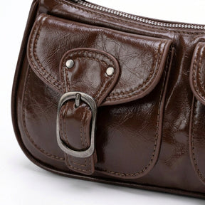 Détail de la poche à rabat, des rivets et de la boucle argentée du sac Garance chocolat