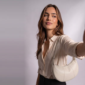 Sac demi-lune en cuir Eugénie blanc cassé porté à l'épaule