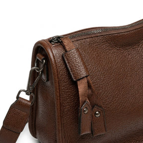 Détail de la tirette à deux languettes rivetées et du mousqueton du sac Clarisse marron