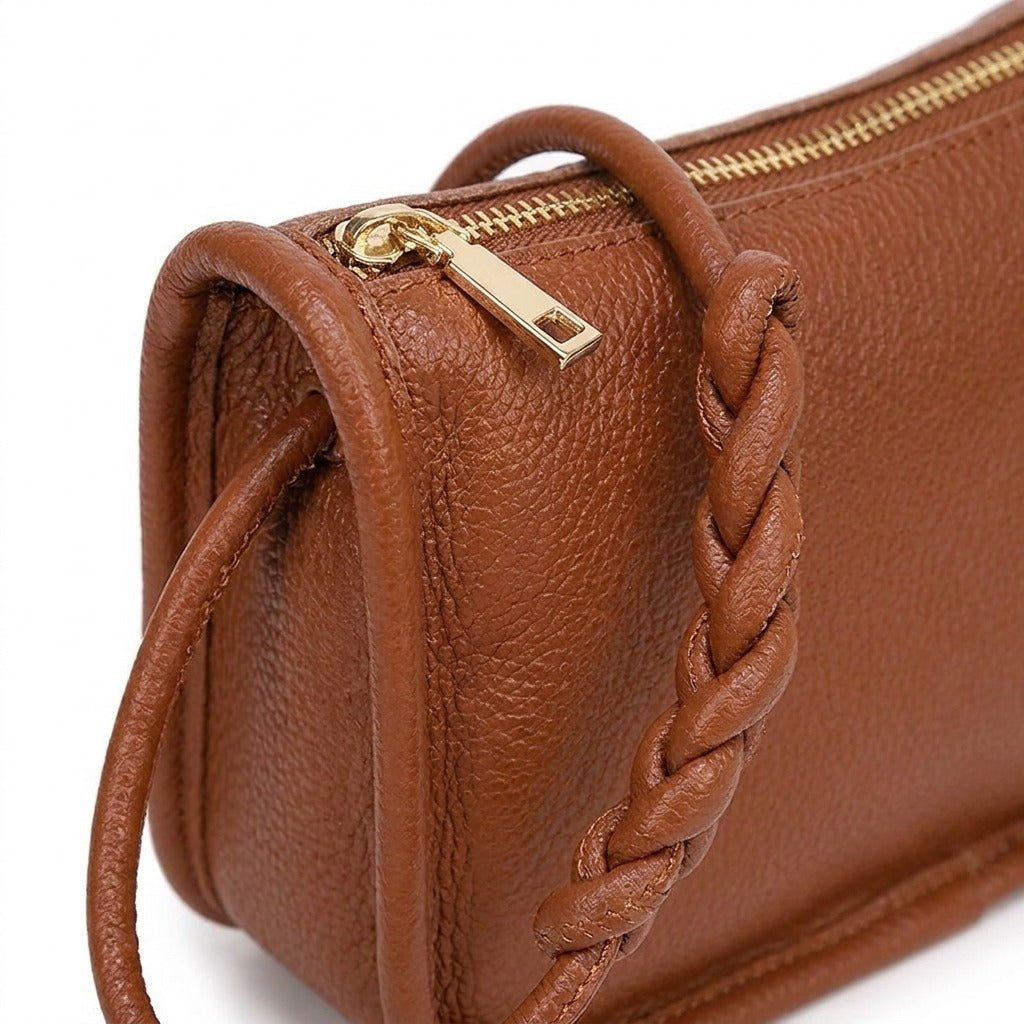 Détail de l'anse tressée et de la tirette dorée du sac Capucine cognac