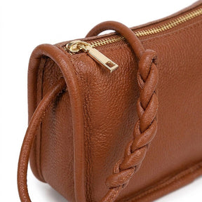 Détail de l'anse tressée et de la tirette dorée du sac Capucine cognac